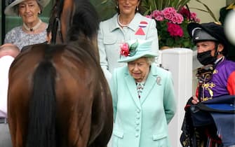 Queen Elizabeth II with racing manager John Warren and jockey Frankie Dettori inspect horse Reach For The Moon during day five of Royal Ascot at Ascot Racecourse. Picture date: Saturday June 19, 2021.