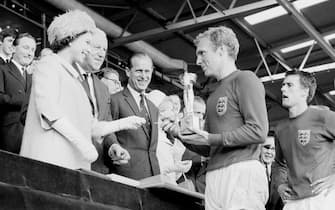 File photo dated 30/07/66 of England captain Bobby Moore holding the Jules Rimet Trophy, collected from Queen Elizabeth II, after winning the World Cup at Wembley, London. As the Queen reaches 25,000 days on the throne on Saturday, the PA news agency looks at some of the events and milestones of her reign.