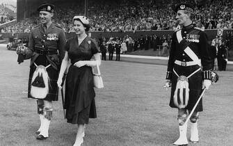 Queen Elizabeth II with the officer in charge of the Guard of Honour of the 1st Battalion of the Glasgow Highlanders, during a Youth Rally at Hampden Park, Glasgow, during her state visit to Scotland, 25th June 1953. (Photo by Topical Press Agency/Hulton Archive/Getty Images)
