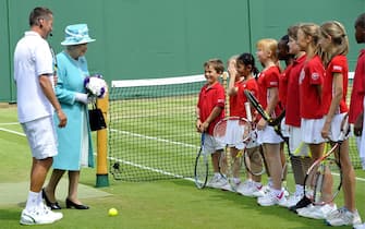 epa02219450 Britain's Queen Elizabeth ll meets a tennis class on the grounds of the All England Lawn Tennis Club during the Wimbledon Championships in London, Britain, 24 June 2010.  EPA/NEIL MUNNS