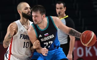 TOPSHOT - Slovenia's Luka Doncic (C) dribbles the ball past France's Evan Fournier in the men's semi-final basketball match between France and Slovenia during the Tokyo 2020 Olympic Games at the Saitama Super Arena in Saitama on August 5, 2021. (Photo by Aris MESSINIS / AFP) (Photo by ARIS MESSINIS/AFP via Getty Images)