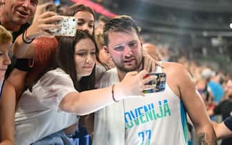 LJUBJLANA, SLOVENIA - 2022/08/17: Luka Doncic of Slovenia takes selfies with fans during the International Friendly basketball between Slovenia and Serbia at Arena Stozice. Final score after extra time was Slovenia 97: 92 Serbia. (Photo by Milos Vujinovic/SOPA Images/LightRocket via Getty Images)