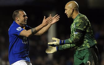 Everton's Dutch midfielder John Heitinga (L) congratulates Everton's American goalkeeper Tim Howard after the keeper scored from his own goal area during the English Premier League football match between Everton and Bolton Wanderers at Goodison Park, Liverpool, north-west England on January 4, 2012. AFP PHOTO/ PAUL ELLIS
RESTRICTED TO EDITORIAL USE. No use with unauthorized audio, video, data, fixture lists, club/league logos or â€œliveâ€  services. Online in-match use limited to 45 images, no video emulation. No use in betting, games or single club/league/player publications. (Photo credit should read PAUL ELLIS/AFP/Getty Images)