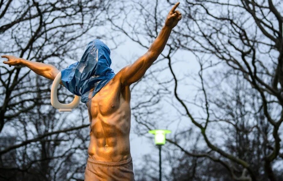 Così appariva la statua questa mattina: volto coperto e un water attorno al braccio