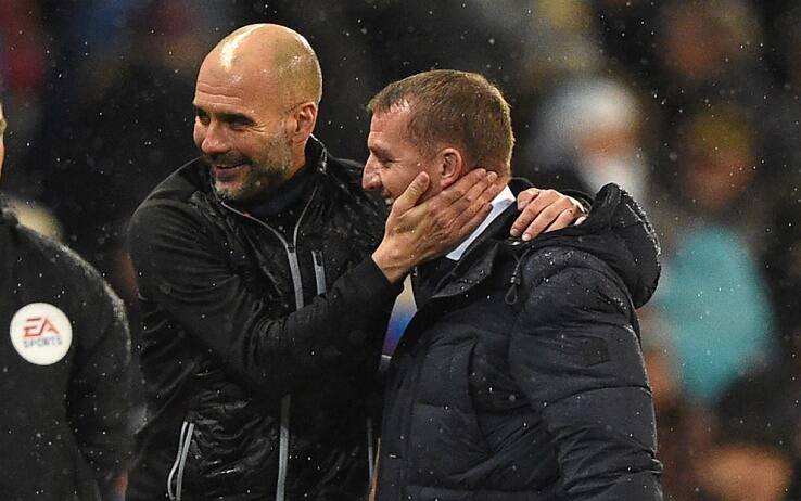 Manchester City's Spanish manager Pep Guardiola (L) embraces Leicester City's Northern Irish manager Brendan Rodgers after the English Premier League football match between Manchester City and Leicester City at the Etihad Stadium in Manchester, north west England, on December 21, 2019. - Manchester City won the game 3-1. (Photo by Oli SCARFF / AFP) / RESTRICTED TO EDITORIAL USE. No use with unauthorized audio, video, data, fixture lists, club/league logos or 'live' services. Online in-match use limited to 120 images. An additional 40 images may be used in extra time. No video emulation. Social media in-match use limited to 120 images. An additional 40 images may be used in extra time. No use in betting publications, games or single club/league/player publications. /  (Photo by OLI SCARFF/AFP via Getty Images)