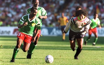 Forward Roger Milla from Cameroon runs past Colombian goalkeeper Jose Higuita (R) after stealing the ball from him on his way to score a goal 23 June 1990 in Naples during the World Cup second round soccer match between Cameroon and Colombia. Milla scored two goals in extra time to help Cameroon defeat Colombia 2-1 (0-0 at the end of regulation time). AFP PHOTO / AFP PHOTO / STAFF        (Photo credit should read STAFF/AFP via Getty Images)