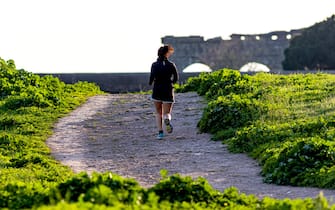 ROME, ITALY - MARCH 20: A woman runs during his jogging across the Aqueducts Park during the Coronavirus emergency in Rome on March 20, 2020, in Rome, Italy. The Italian government continues to enforce the nationwide lockdown measures to control the spread of COVID-19. (Photo by Stefano Montesi - Corbis/ Getty Images)