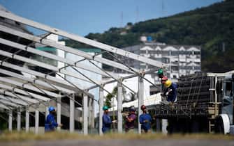 Men work in the construction of a temporary field hospital for coronavirus patients at Maracana stadium complex, where the Celio de Barros athletics track used to be located, in Rio de Janeiro, Brazil on April 02, 2020. - Brazil's most famous stadium allowed health authorities to turn part of its complex into a field hospital to face the coronavirus pandemic. (Photo by MAURO PIMENTEL / AFP) (Photo by MAURO PIMENTEL/AFP via Getty Images)