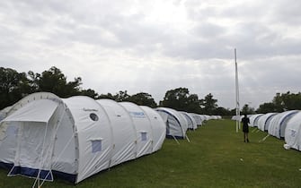 A man walks between tents at the Pretoria West Rugby Stadium in Pretoria on April 1, 2020 where homeless people are sheltered while trying to enforce a national lockdown amid concern of the spread of COVID-19 coronavirus. - South Africa came under a nationwide lockdown on March 27, 2020, joining other African countries imposing strict curfews and shutdowns in an attempt to halt the spread of the COVID-19 coronavirus across the continent. (Photo by Phill Magakoe / AFP) (Photo by PHILL MAGAKOE/AFP via Getty Images)