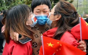 Medical staff members kisses their relative after returning home from Wuhan helping with the COVID-19 coronavirus recovery effort, in Bozhou, in China's eastern Anhui province on April 10, 2020. (Photo by STR / AFP) / China OUT (Photo by STR/AFP via Getty Images)