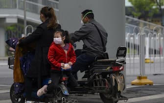 People wearing masks ride on their scooters in Wuhan, China's central Hubei province on April 10, 2020. (Photo by NOEL CELIS / AFP) (Photo by NOEL CELIS/AFP via Getty Images)