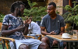 In this photo taken on April 11, 2020, Real Kashmir Football Club (RKFC) players Armand Bazie (L) and Gnohere Krizo of Ivory Coast chat at a restaurant hotel during a government-imposed nationwide lockdown as a preventive measure against the COVID-19 coronavirus, in Srinagar. - Stranded by the coronavirus lockdown in one of the world's most militarised regions, Zambia's Aaron Katebe is one of 10 foreign footballers reduced to playing video games or training in a hotel gym in Indian-administered Kashmir. (Photo by Tauseef MUSTAFA / AFP) (Photo by TAUSEEF MUSTAFA/AFP via Getty Images)