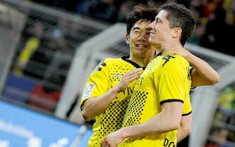 epa03123102 Dortmund's Robert Lewandowski (R) celebrates with his teammate Shinji Kagawa (L) after scoring the 1-0 lead during the German Bundesliga soccer match between Borussia Dortmund and Hanover 96 in Dortmund, Germany, 26 February 2012. (ATTENTION: EMBARGO CONDITIONS! The DFL permits the further utilisation of the pictures in IPTV, mobile services and other new technologies only no earlier than two hours after the end of the match. The publication and further utilisation in the internet during the match is restricted to 15 pictures per match only.)  EPA/MARIUS BECKER