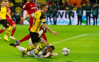 DORTMUND, GERMANY - NOVEMBER 10: Marco Reus of Borussia Dortmund and Goalkeeper Manuel Neuer of Bayern Muenchen battle for the ball during the Bundesliga match between Borussia Dortmund and FC Bayern Muenchen at Signal Iduna Park on November 10, 2018 in Dortmund, Germany.(Photo by TF-Images/Getty Images)
