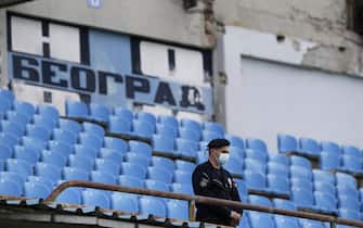 epa08453144 A police officer wearing a protective face mask stands guard during the Serbian SuperLiga soccer match between Rad and Red Star in Belgrade, Serbia, 29 May 2020. The Serbian SuperLiga resumes without spectators after a suspension because of the coronavirus pandemic.  EPA/ANDREJ CUKIC