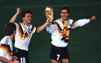 ROME, ITALY - JULY 8: Lothar Matthaeus (L) and Pierre Littbarski of Germany celebrates with the trophy after winning the World Cup final match between Argentina and Germany at the Olympic Stadium on July 8, 1990 in Rome, Italy. (Photo by Bongarts/Getty Images)