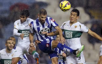 Deportivo Coruna's defender Alberto Lopo (C) heads for the ball with Elche CF's defenders, Chilean Enzo Roco (L) and Jose Angel Alonso (R) during the Spanish Liga Primera Division soccer match played at the Riazor stadium, in A Coruna, northwestern Spain, 15 December 2014. EFE/Cabalar