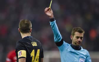 French referee Clement Turpin shows Atletico Madrid's Spanish midfielder Gabi the yellow card during the UEFA Champions League group D football match between FC Bayern Munich and Atletico Madrid in Munich, southern Germany, on December 6, 2016.  / AFP / GUENTER SCHIFFMANN        (Photo credit should read GUENTER SCHIFFMANN/AFP via Getty Images)