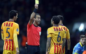 epa04985881 A referee shows a yellow card to Dani Alves (C-R) of FC Barcelona during the UEFA Champions League qualifying soccer match between FC BATE Borisov and FC Barcelona in Borisov, Belarus, 20 October 2015.  EPA/TATYANA ZENKOVICH