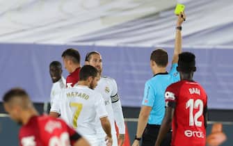 epa08507258 Real Madrid's defender Sergio Ramos (L) is booked with a yellow card by referee Mario Melero Lopez during the Spanish LaLiga match between Real Madrid and RCD Mallorca at Alfredio Di Stefano stadium in Madrid, Spain, 24 June 2020.  EPA/JUANJO MARTIN