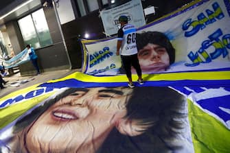OLIVOS, ARGENTINA - NOVEMBER 03: Fans display flags with the face of Diego Maradona outside of ClÃ­nica Olivos on November 03, 2020 in Olivos, Argentina. Personal doctor of Maradona, Leopoldo Luque, confirmed the former footballer will under a surgery to treat a clot in his brain. Maradona, who turned 60 on Friday 30, had spent the night of Monday hospitalized after being admitted with symptoms of depression. (Photo by Marcos Brindicci/Getty Images)