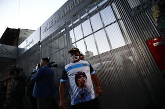 OLIVOS, ARGENTINA - NOVEMBER 03: A fan of Diego Maradona awaits outside of ClÃ­nica Olivos on November 03, 2020 in Olivos, Argentina. Personal doctor of Maradona, Leopoldo Luque, confirmed the former footballer will under a surgery to treat a clot in his brain. Maradona, who turned 60 on Friday 30, had spent the night of Monday hospitalized after being admitted with symptoms of depression. (Photo by Marcos Brindicci/Getty Images)