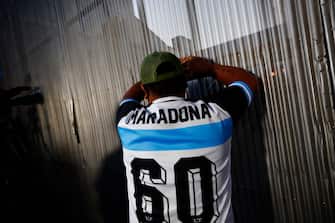 OLIVOS, ARGENTINA - NOVEMBER 03: A fan of Diego Maradona awaits outside of ClÃ­nica Olivos on November 03, 2020 in Olivos, Argentina. Personal doctor of Maradona, Leopoldo Luque, confirmed the former footballer will under a surgery to treat a clot in his brain. Maradona, who turned 60 on Friday 30, had spent the night of Monday hospitalized after being admitted with symptoms of depression. (Photo by Marcos Brindicci/Getty Images)