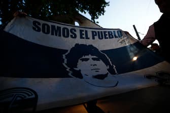 OLIVOS, ARGENTINA - NOVEMBER 03: Fans show a flag of Gimnasia Esgrima La Plata with the face of Diego Maradona at ClÃ­nica Olivos on November 03, 2020 in Olivos, Argentina. Personal doctor of Maradona, Leopoldo Luque, confirmed the former footballer will under a surgery to treat a clot in his brain. Maradona, who turned 60 on Friday 30, had spent the night of Monday hospitalized after being admitted with symptoms of depression. (Photo by Marcos Brindicci/Getty Images)