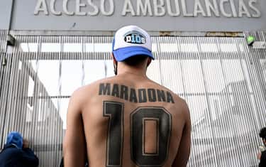 A supporter of Argentine former football star and coach of Gimnasia y Esgrima La Plata Diego Maradona displays his tattoo, outside the hospital where he will undergo brain surgery for a blood clot, in Olivos, Buenos Aires province, on November 3, 2020. (Photo by JUAN MABROMATA / AFP) (Photo by JUAN MABROMATA/AFP via Getty Images)