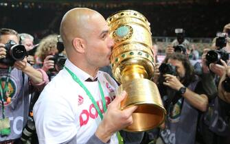 epa05322243 Munich's coach Pep Guardiola (C) celebrates with the trophy after winning the German DFB Cup final soccer match between Bayern Munich and Borussia Dortmund at the Olympic Stadium in Berlin, Germany, 21 May 2016. 
(EMBARGO CONDITIONS - ATTENTION: The DFB prohibits the utilisation and publication of sequential pictures on the internet and other online media during the match (including half-time). ATTENTION: BLOCKING PERIOD! The DFB permits the further utilisation and publication of the pictures for mobile services (especially MMS) and for DVB-H and DMB only after the end of the match.)  EPA/KAY NIETFELD