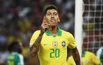 epa07909908 Roberto Firmino of Brazil celebrates after scoring the first goal against Senegal during an international friendly match between Brazil and Senegal at the National Stadium in Singapore, 10 October 2019.  EPA/WALLACE WOON