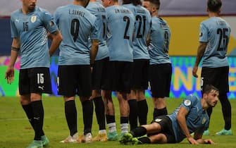 Uruguay's Matias Vina lies on the ground behind the wall during a free-kick to be taken by Argentina's Lionel Messi (out of frmae) during their Conmebol Copa America 2021 football tournament group phase match at the Mane Garrincha Stadium in Brasilia, on June 18, 2021. (Photo by NELSON ALMEIDA / AFP) (Photo by NELSON ALMEIDA/AFP via Getty Images)