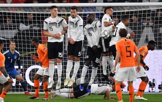 GELSENKIRCHEN, GERMANY - NOVEMBER 19:  Joshua Kimmich of Germany lies on the pitch behind the defensive wall as Memphis Depay of the Netherlands takes a free kick during the UEFA Nations League A group one match between Germany and Netherlands at Veltins-Arena on November 19, 2018 in Gelsenkirchen, Germany.  (Photo by Stuart Franklin/Bongarts/Getty Images)