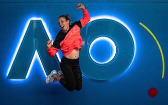 epa08140066 A woman posing for photos jumps in front of the Australian Open logo ahead of the Australian Open Grand Slam tennis tournament in Melbourne, Victoria, Australia, 19 January 2020. The Australian Open 2020 will take place at Melbourne Park from 20 January to 02 February.  EPA/ROMAN PILIPEY