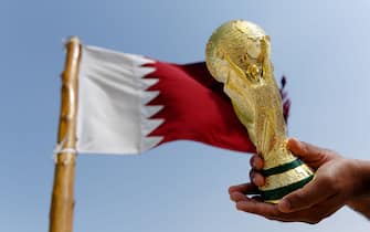 DOHA, QATAR - January 25 : A general view of a replica of the FIFA World Cup Trophy by the national flag of Qatar at the Al Zubara Fort, a UNESCO World Heritage Site, in Madinat ash Shamal, Qatar Al Zubara fort in the North of Qatar, the host country of the Qatar 2022 FIFA World Cup on January 25 2016 in Doha, Qatar. (Photo by Matthew Ashton - AMA/Getty Images)