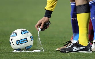 epa02834083 Mexican referee Francisco Chacon uses spray to mark the position for a free kick during the over time of the Copa America 2011 semifinal match Paraguay vs Venezuela at Malvinas Argentinas Stadium in Mendoza, Argentina, on 20 July 2011.  EPA/IVAN FRANCO