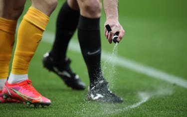 epa09041372 Referee Mike Dean uses vanishing spray during the English Premier League soccer match between Newcastle United and Wolverhampton Wanderers in Newcastle, Britain, 27 February 2021.  EPA/Alex Pantling / POOL EDITORIAL USE ONLY. No use with unauthorized audio, video, data, fixture lists, club/league logos or 'live' services. Online in-match use limited to 120 images, no video emulation. No use in betting, games or single club/league/player publications.