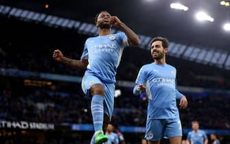 Manchester City's Raheem Sterling celebrates scoring their side's fourth goal of the game with Bernardo Silva (right) during the Premier League match at The Etihad Stadium, Manchester. Picture date: Sunday December 26, 2021.