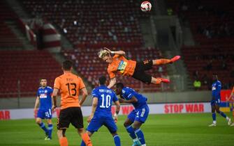 Shakhtar Donetsk's Ukrainian forward Mykhailo Mudryk (up) jumps in front of   Olympiacos FC's Portuguese midfielder Rony Lopes (C) during a friendly charity football match between Shakhtar Donetsk and Olympiacos FC for peace and the end of war in Ukraine, at the Karaiskaki Stadium in Athens, on April 9, 2022. (Photo by ANGELOS TZORTZINIS / AFP) (Photo by ANGELOS TZORTZINIS/AFP via Getty Images)