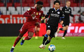 epa09607709 Munich's Alphonso Davies (L) in action against Bielefeld's Masaya Okugawa (R) during the German Bundesliga soccer match between Bayern Muenchen and Arminia Bielefeld in Munich, Germany, 27 November 2021.  EPA/PHILIPP GUELLAND CONDITIONS - ATTENTION: The DFL regulations prohibit any use of photographs as image sequences and/or quasi-video.