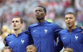 15 July 2018, Russia, Moscow: Soccer, World Cup 2018: Final game, France vs. Croatia at the Luzhniki Stadium. France's Antoine Griezmann (left to right), Paul Pogba and Kylian Mbappe during the national anthem. Photo: Christian Charisius/dpa