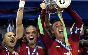 epa05419886 Cristiano Ronaldo of Portugal (R) holds the trophy next to teammates Ricardo Quaresma (L) and Pepe after winning the UEFA EURO 2016 Final match between Portugal and France at Stade de France in Saint-Denis, France, 10 July 2016.

(RESTRICTIONS APPLY: For editorial news reporting purposes only. Not used for commercial or marketing purposes without prior written approval of UEFA. Images must appear as still images and must not emulate match action video footage. Photographs published in online publications (whether via the Internet or otherwise) shall have an interval of at least 20 seconds between the posting.)  EPA/TIBOR ILLYES HUNGARY OUT  EDITORIAL USE ONLY