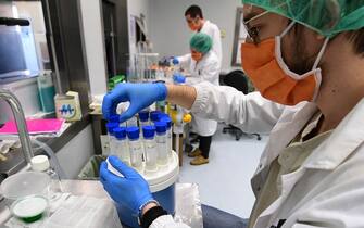 1210035285 A scientific staff prepares little bottles to do the Bioburden test to evaluate the presence of microbes on surgical masks in an operating room transformed into a laboratory, at the Policlinico Sant'Orsola-Malpighi hospital in Bologna on April 15, 2020, during a lockdown aimed at curbing the spread of the COVID-19 pandemic, caused by the novel coronavirus. - This laboratory is the only one in Italy that tests protections for medical use according to the European standard. (Photo by Miguel MEDINA / AFP) (Photo by MIGUEL MEDINA/AFP via Getty Images)