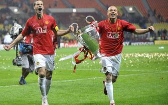 Manchester United's captain Rio Ferdinand (L) and Wes Brown run with the trophy after beating Chelsea in the final of the UEFA Champions League football match at the Luzhniki stadium in Moscow on May 21, 2008. The match remained at a 1-1 draw and Manchester won on penalties after extra time.      AFP PHOTO / Franck Fife (Photo credit should read FRANCK FIFE/AFP via Getty Images)