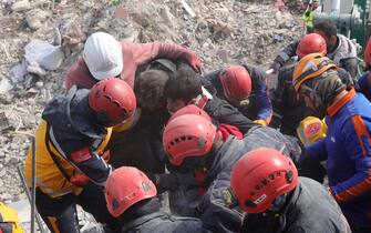 epa10458565 Ibrahim Kantrji, 20, is rescued from the rubble of a collapsed building after being trapped for 4 days following a powerful earthquake in the city of Kahramanmaras, Turkey, 10 February 2023. More than 21,000 people have died and thousands more are injured after two major earthquakes struck southern Turkey and northern Syria on 06 February. Authorities fear the death toll will keep climbing as rescuers look for survivors across the region.  EPA/ABIR SULTAN