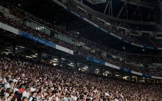 Real Madrid fans hold up their cellphone lights as they watch live on large screens the 2022 UEFA Champions League final match between Liverpool and Real Madrid at the Santiago Bernabeu stadium in Madrid. Real Madrid won its 14th championship after beating Liverpool 1-0 at the Stade de France in Saint-Denis stadium in France.