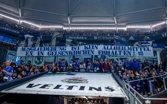 14 April 2023, North Rhine-Westphalia, Gelsenkirchen: Soccer: Bundesliga, FC Schalke 04 - Hertha BSC, Matchday 28, Veltins Arena: Berlin fans display a banner reading "Spin-off is no panacea. Keep E.V. in Gelsenkirchen!". Photo: David Inderlied/dpa - IMPORTANT NOTE: In accordance with the requirements of the DFL Deutsche Fußball Liga and the DFB Deutscher Fußball-Bund, it is prohibited to use or have used photographs taken in the stadium and/or of the match in the form of sequence pictures and/or video-like photo series.