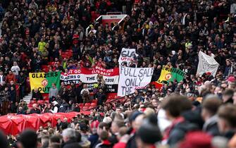 Manchester United fans with banners aimed at the club's owners are seen in the stands before the Emirates FA Cup quarter-final match at Old Trafford, Manchester. Picture date: Sunday March 19, 2023.