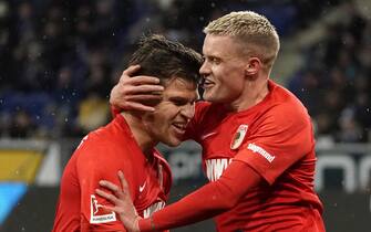 epa08069766 Philipp Max of Augsburg (R) celebrates with Florian Niederlechner after scoring the opening goal during the German Bundesliga soccer match between TSG 1899 Hoffenheim and FC Augsburg in Sinsheim, Germany, 13 December 2019.  EPA/RONALD WITTEK CONDITIONS - ATTENTION: The DFL regulations prohibit any use of photographs as image sequences and/or quasi-video.