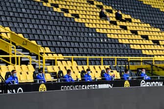 Schalke alternate players sit on the bench during the German first division Bundesliga football match BVB Borussia Dortmund v Schalke 04 on May 16, 2020 in Dortmund, western Germany as the season resumed following a two-month absence due to the novel coronavirus COVID-19 pandemic. (Photo by Martin Meissner / POOL / AFP) / DFL REGULATIONS PROHIBIT ANY USE OF PHOTOGRAPHS AS IMAGE SEQUENCES AND/OR QUASI-VIDEO (Photo by MARTIN MEISSNER/POOL/AFP via Getty Images)